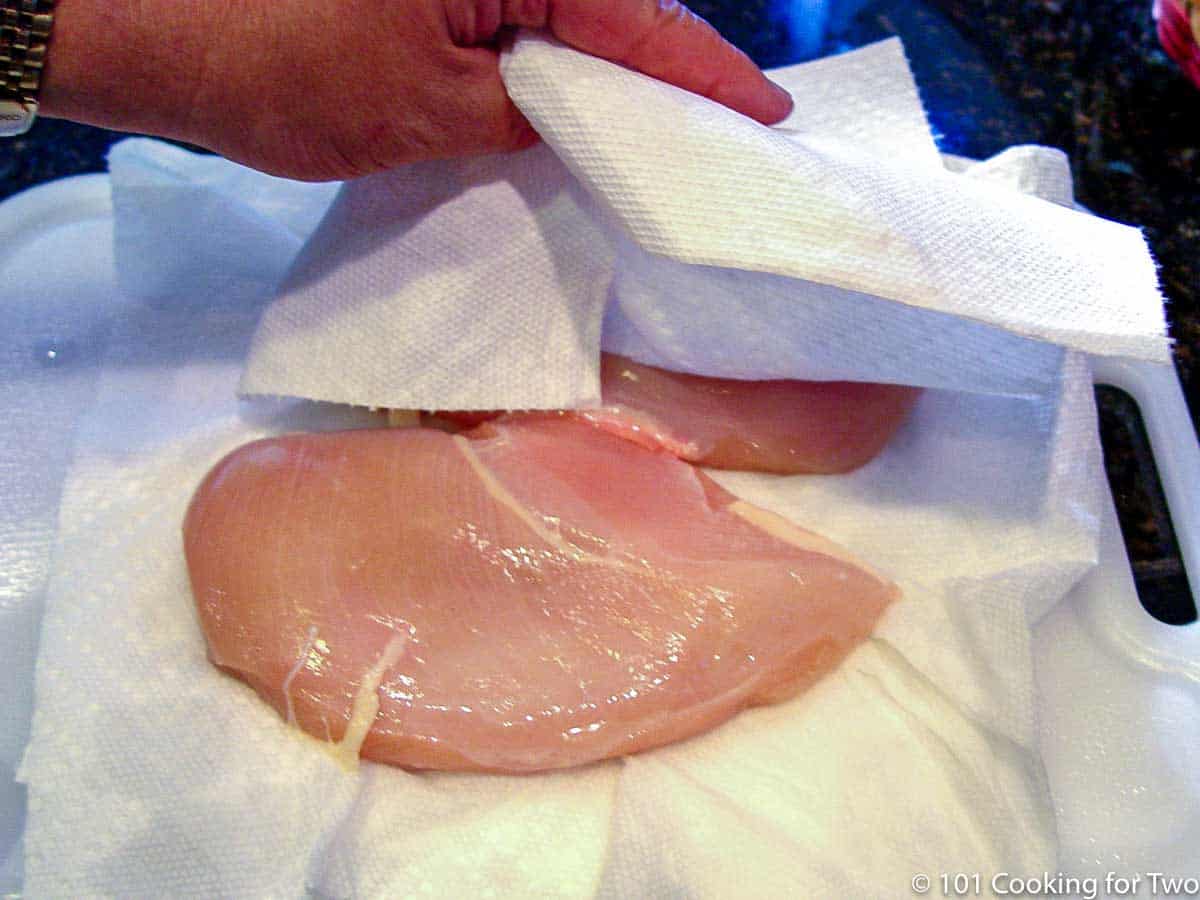 patting dry chicken breasts with paper towels
