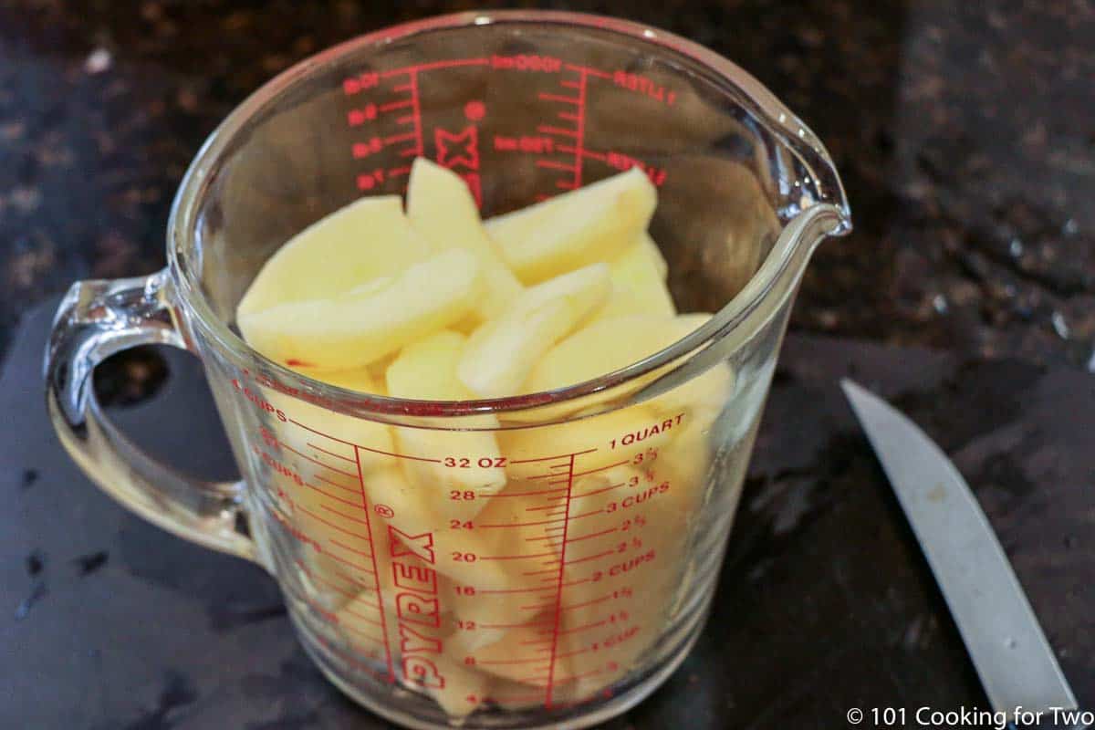 slices of apple in measuring cup.