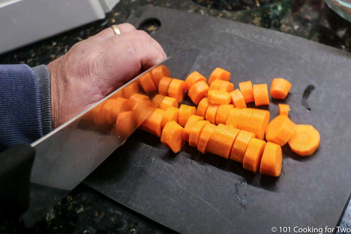slicing carrots on a black board.