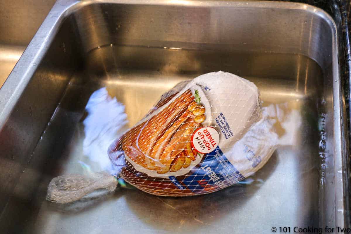 turkey breast in sink with water.