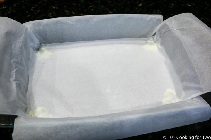 baking pan lined with crossing sheets of parchment paper