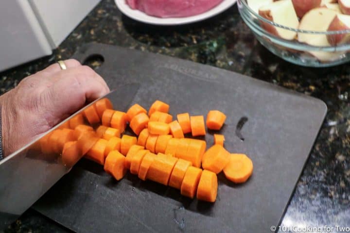 cutting carrots on a black board