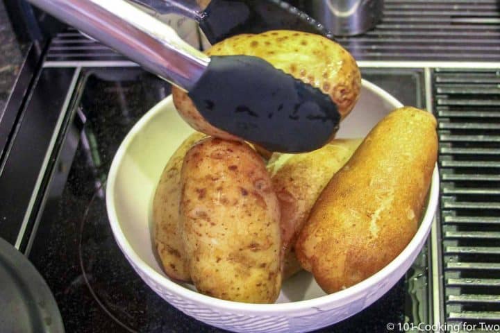 moving cooked potatoes to a dish to cool