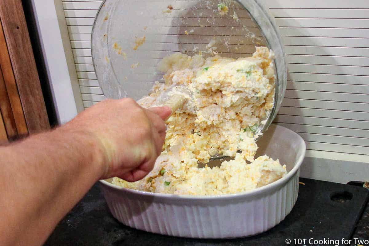 moving raw potato casserole into baking dish.