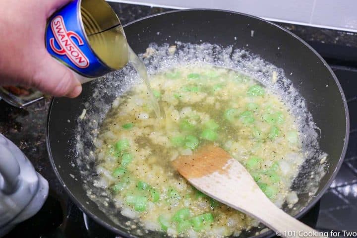 pouring broth into the thickened sauce in a plack pan