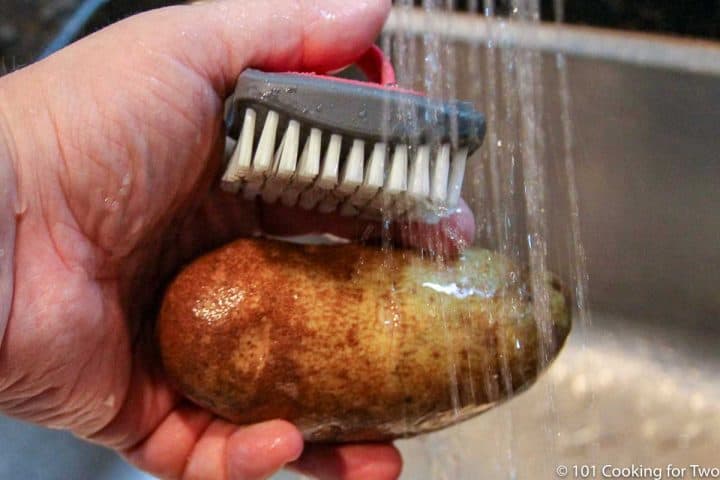 scrubing potatoes under running water