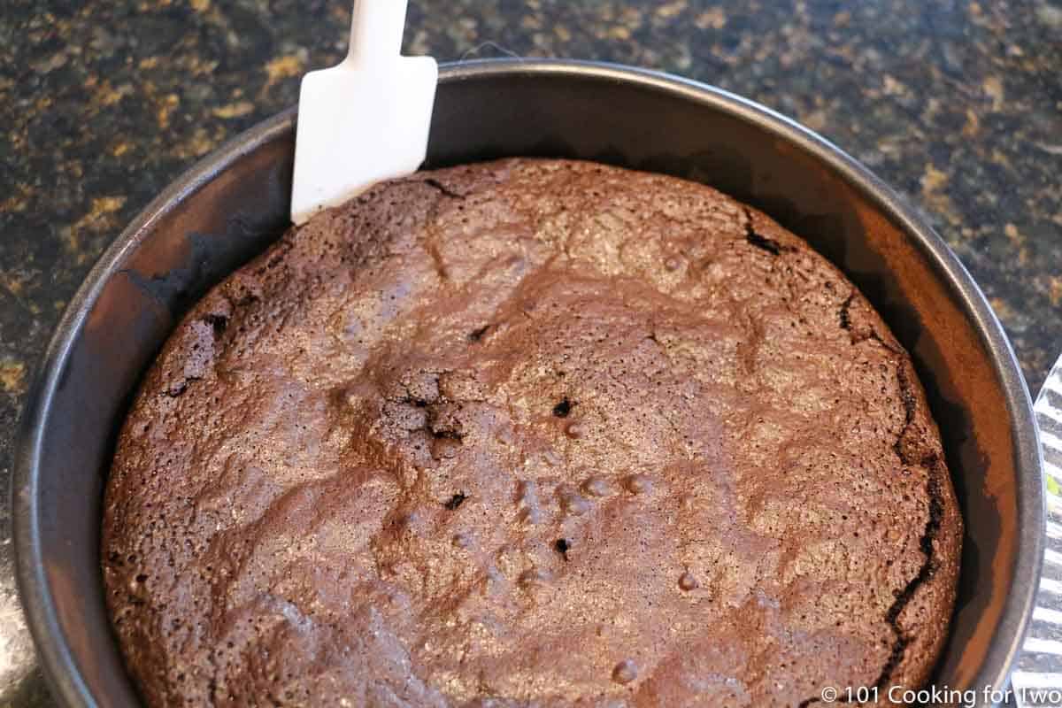 spatula loosening the cake in the pan