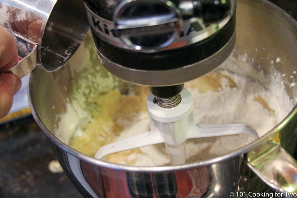 adding flour to the stand mixer.