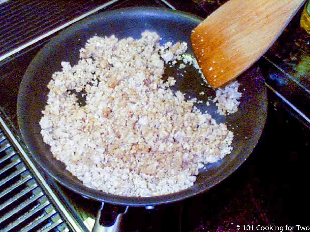 bread crumbs in skillet with wooden spoon.