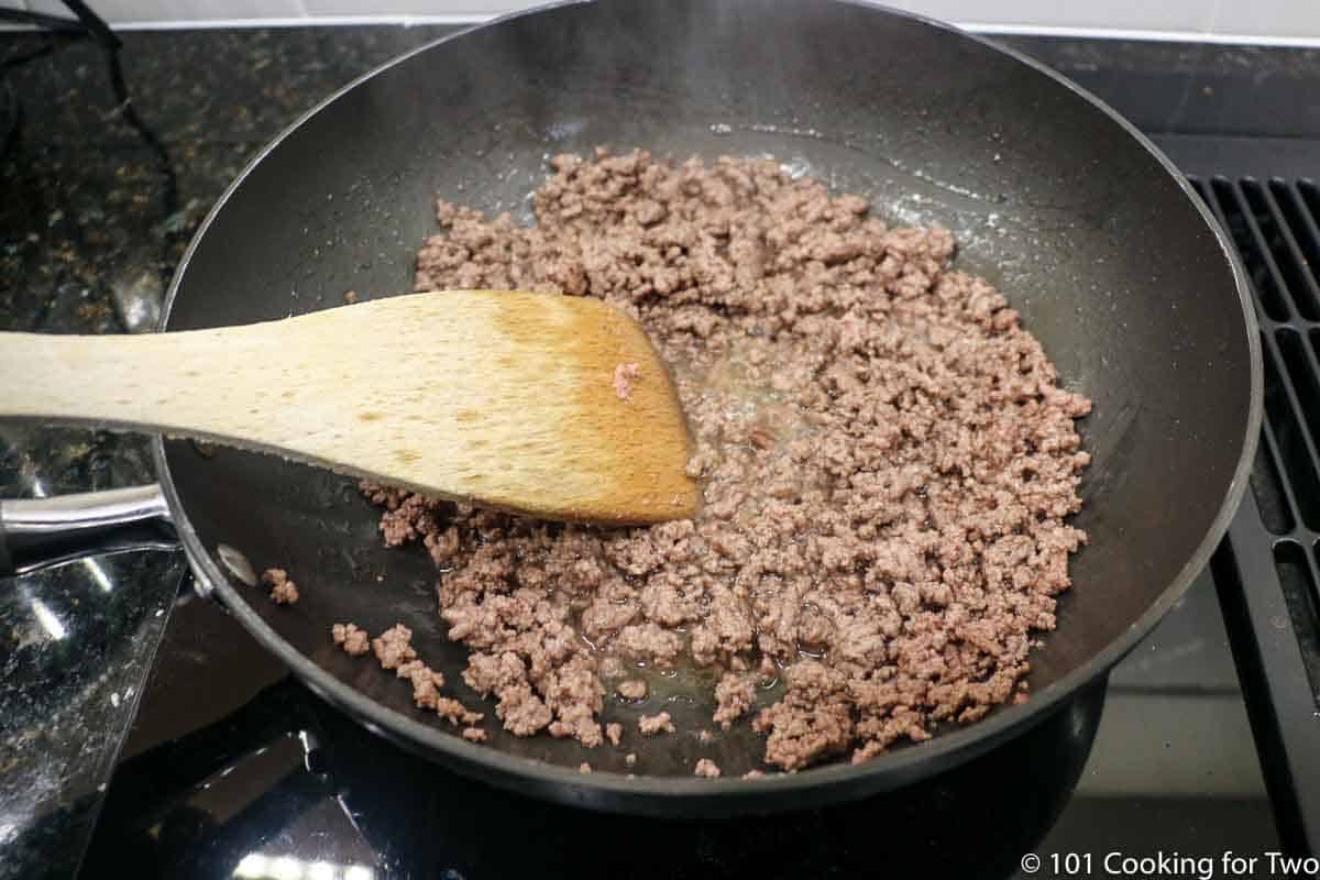 browning ground meat in a black pan.