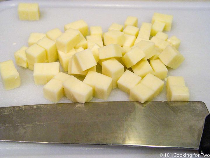 cheese chopped in cubes on white board