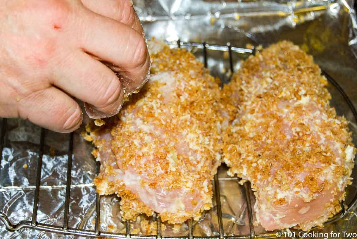 chicken on the tray adding more breading.