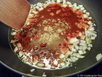 cooking onion and spices in black pan