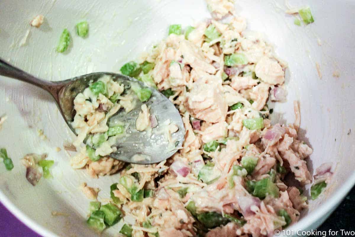 mixing chicken salad in a bowl