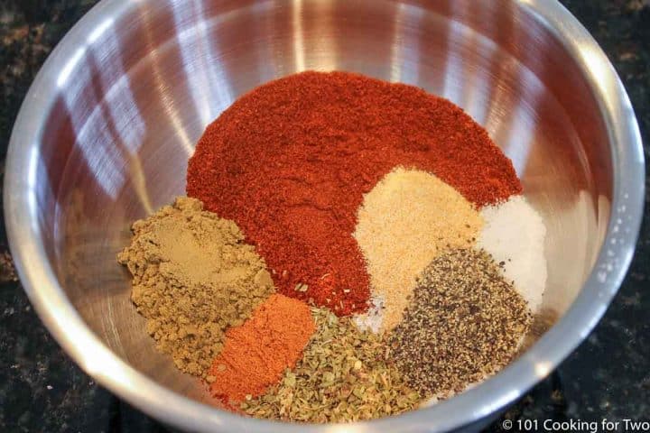mixing taco spices in silver bowl