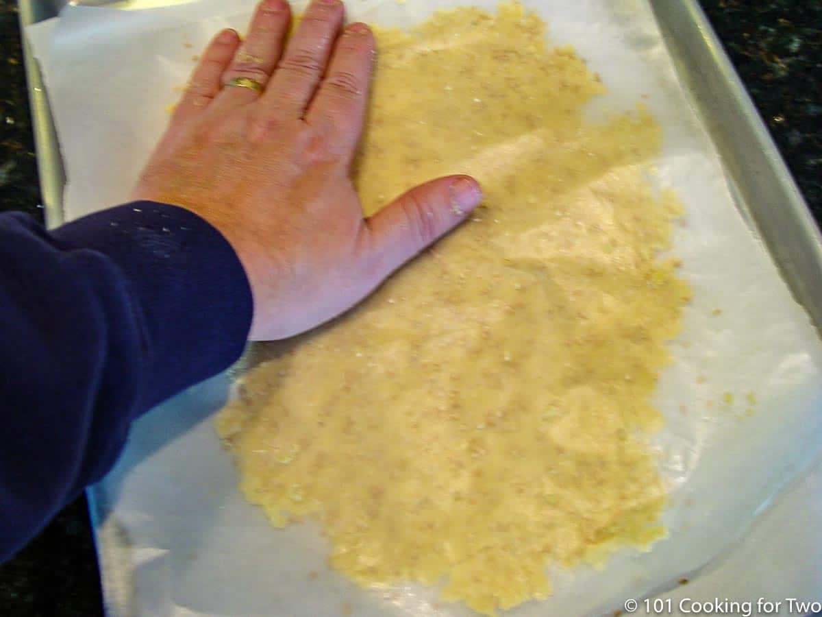 raw dough covered with wax paper to pat in the salt and seeds