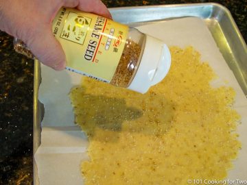 sprinkling sesame seeds on the rolled out dough