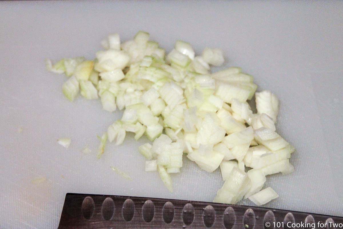 chopped onion on white board.