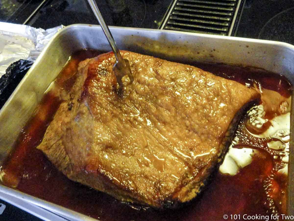 cooked brisket with a large for checking for tender.