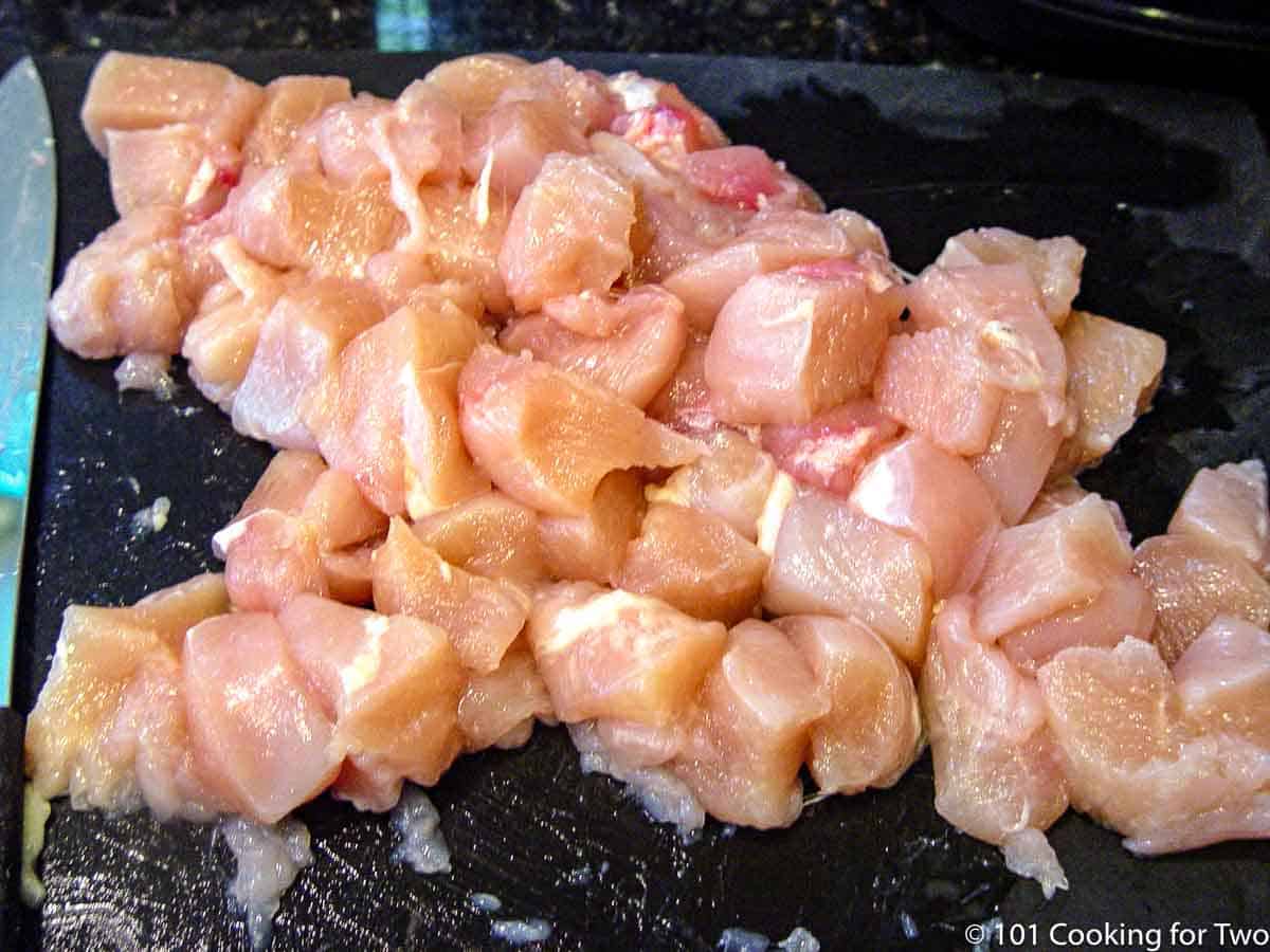 pile of chichen breast cut into cubes.