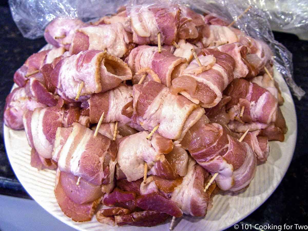 plate full of bacon wrapped chicken cubes.