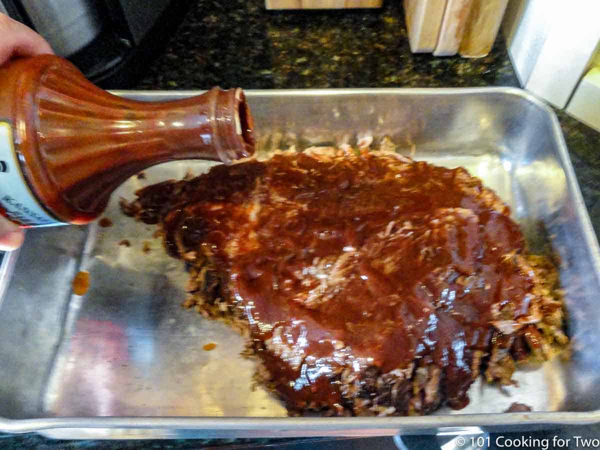 pouring sauce on sliced brisket