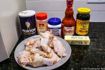raw chicken wings on plate with seasonings