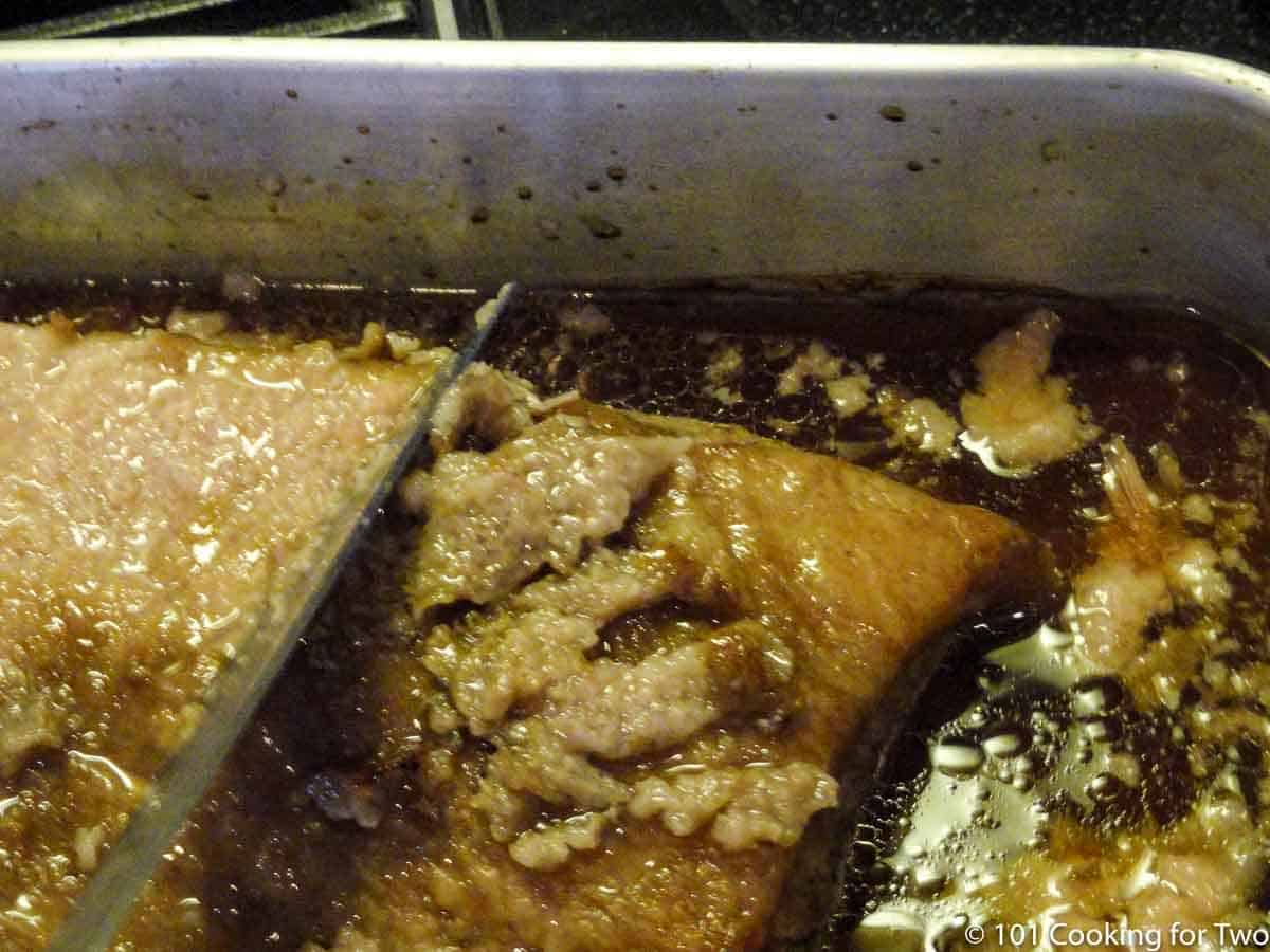scraping fat off cooked brisket