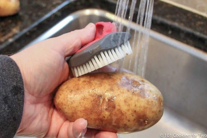 scrubing a potato under running water