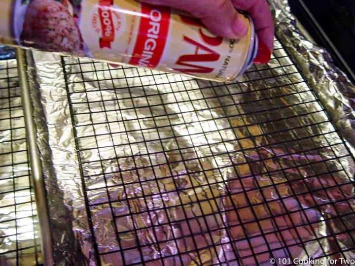 spraying rack on foil covered tray with PAM