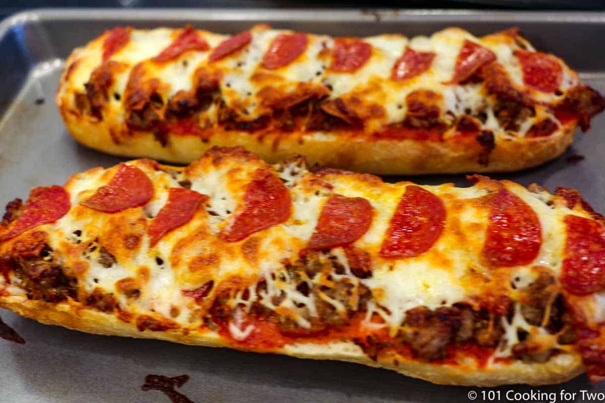 French bread pizzas coming out of oven.