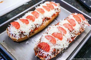 French bread pizzas topped and ready to bake