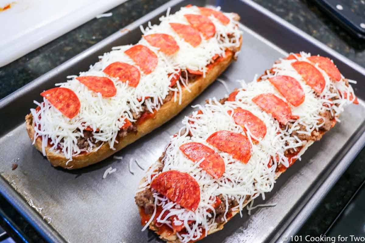 French bread pizzas topped and ready to bake.