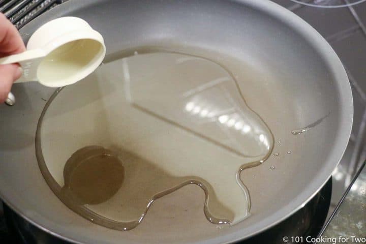 adding oil to a frying pan