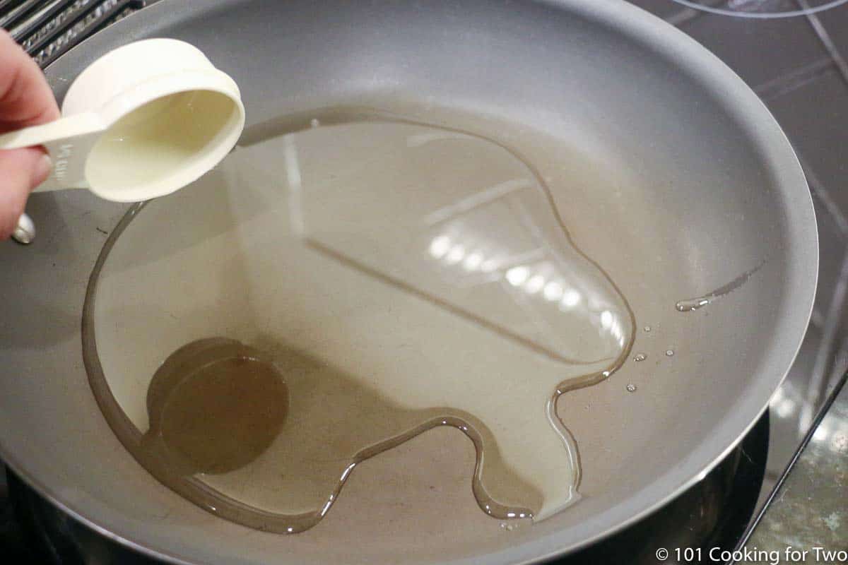 adding oil to a frying pan.