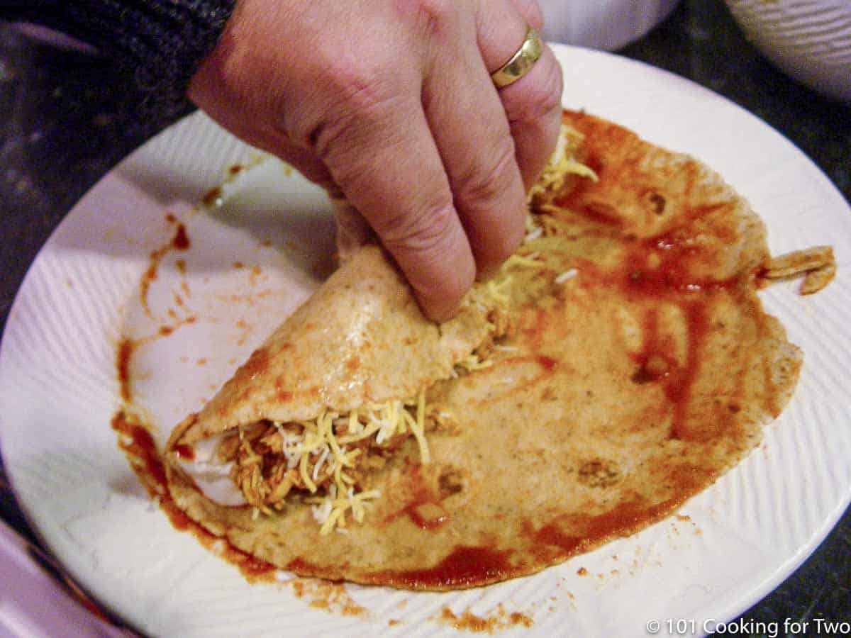 filled tortilla being rolled up.