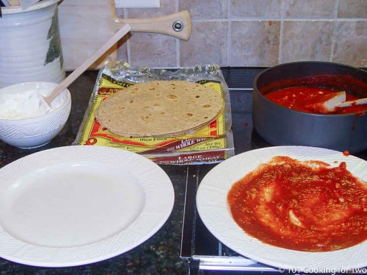 plate with sauce ready to start coating tortillas