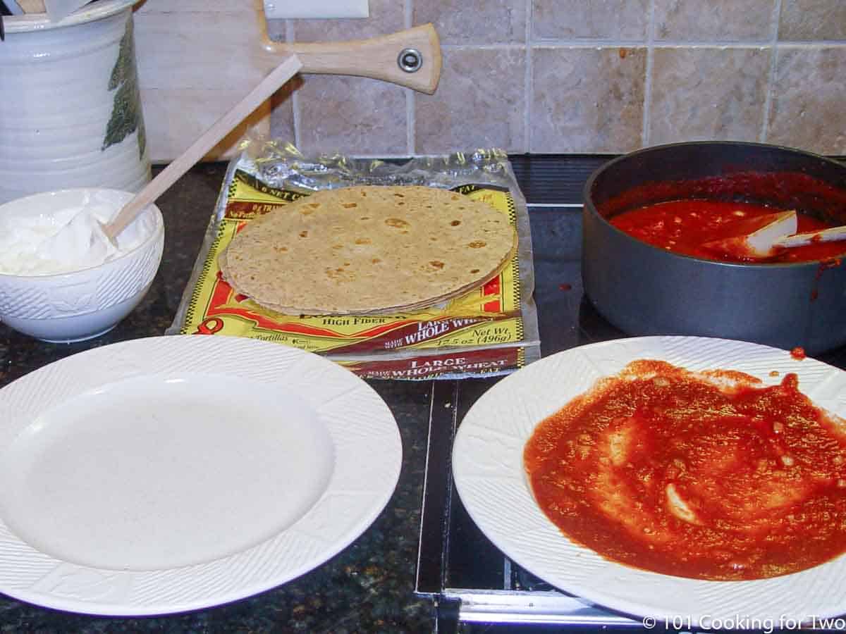 plate with sauce ready to start coating tortillas
