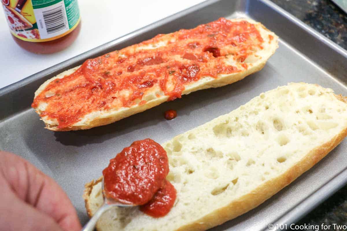 spreading sauce on French bread halves.