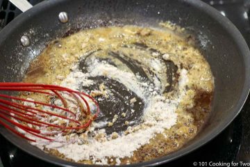 whisking flour into droppings in pan