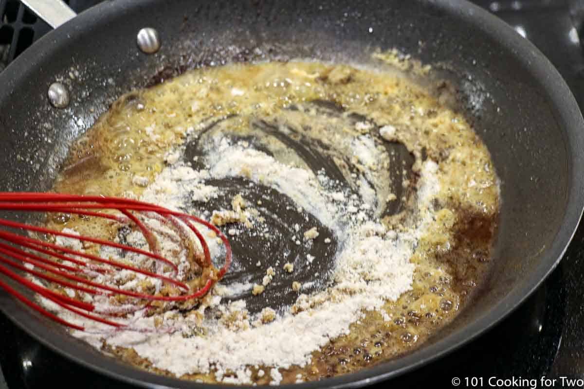 whisking flour into droppings in pan.