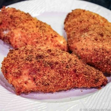 Parmesan coated chicken on a white plate