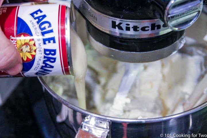 adding sweetened condenced milk to the cream cheese in a stand mixer