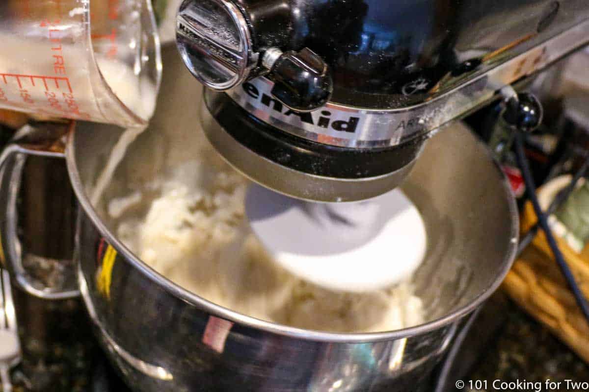 adding yeast mixture to stand mixer