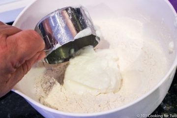 adding yogurt to the bowl with dry ingredients