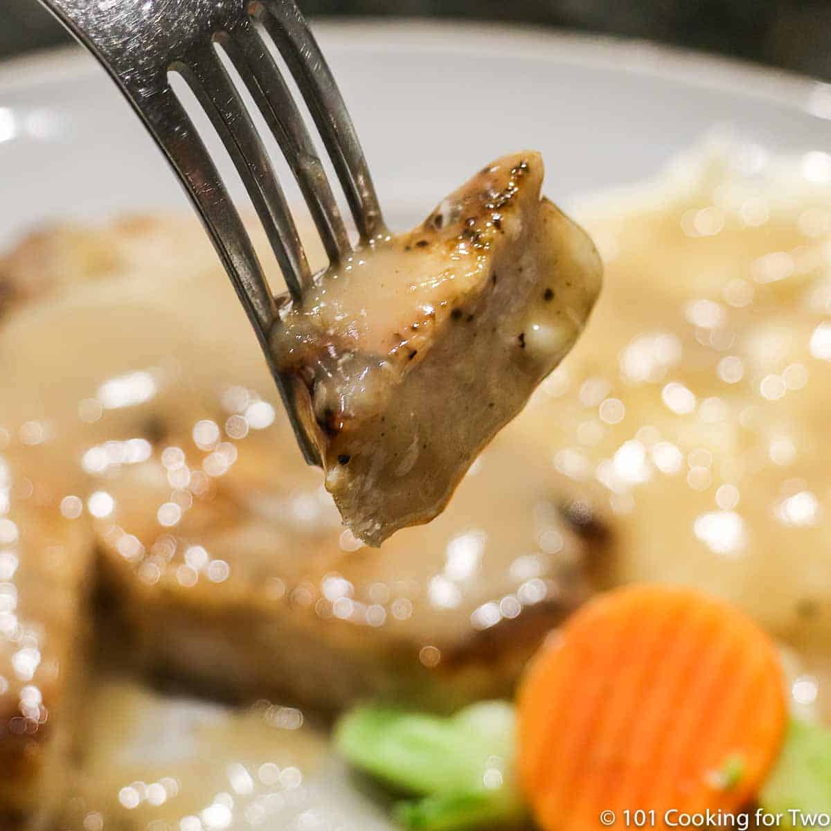 bite of pork chop on a fork,