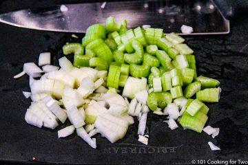 chopped celery and onion on a black board