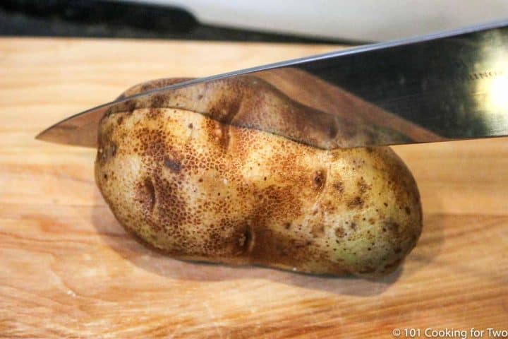 cutting a russet potato in half