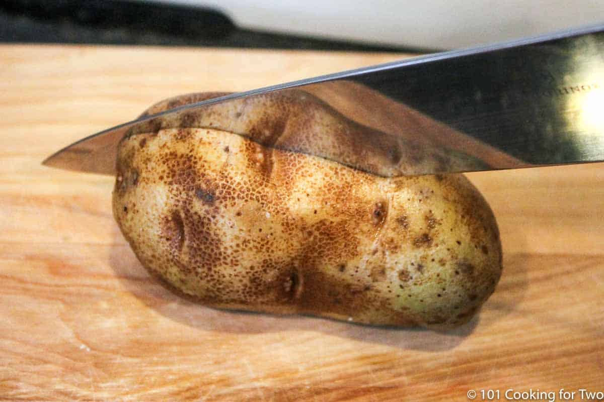 cutting a russet potato in half.