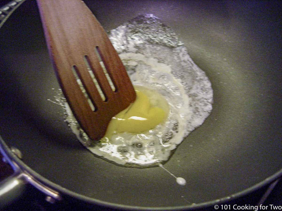 frying an egg in a frying pan.